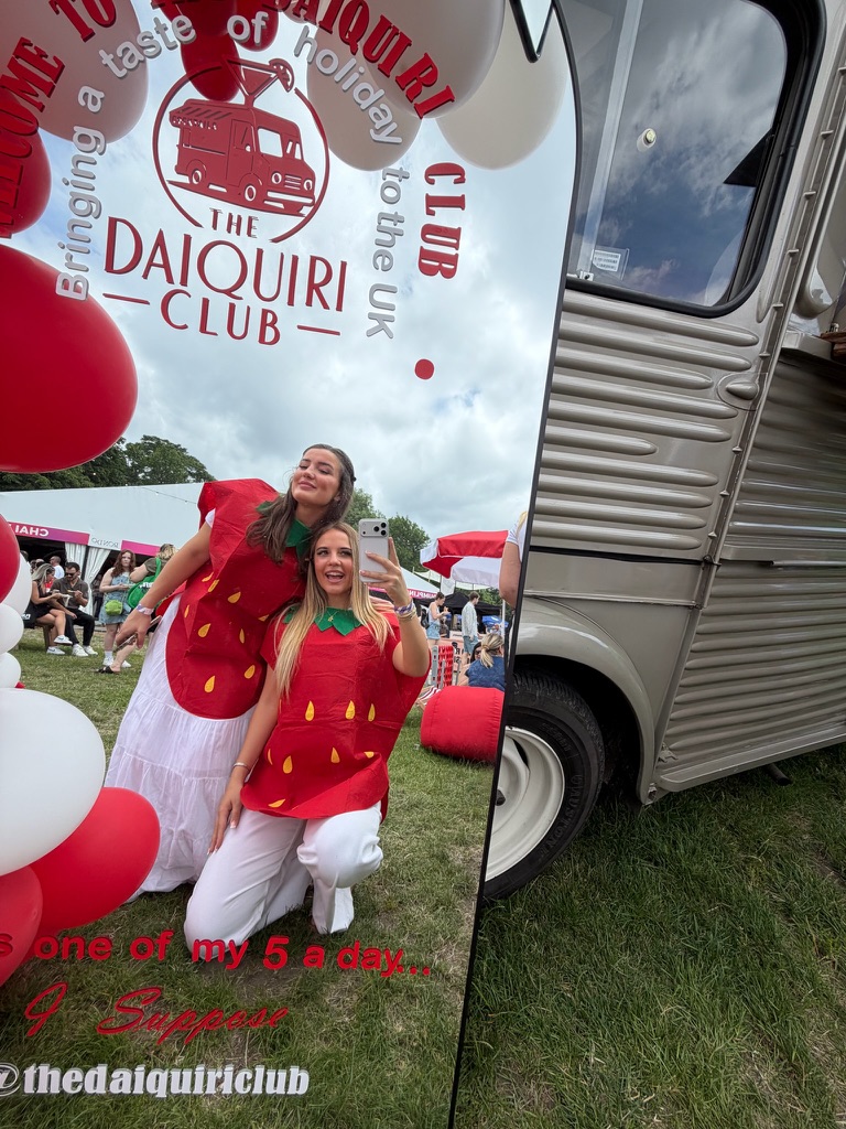 Team members in strawberry costumes beside the van