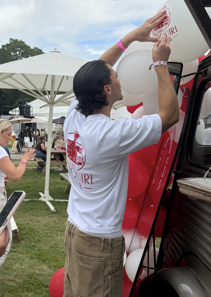 Noah applying Daiquiri Club branding to the van