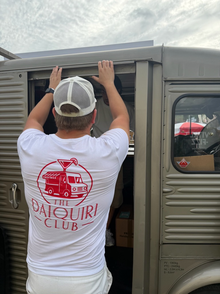 Team member in Daiquiri Club tee setting up the van